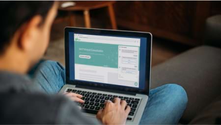 ノートパソコンにタイプ入力している男性