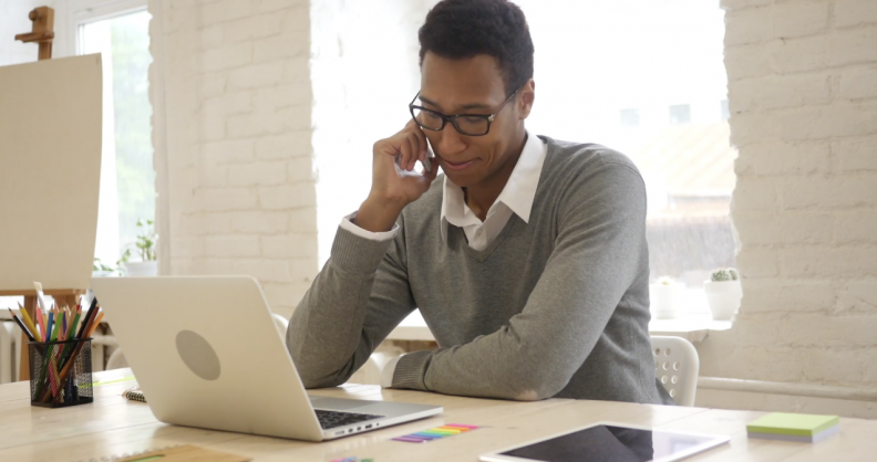 person on phone with laptop